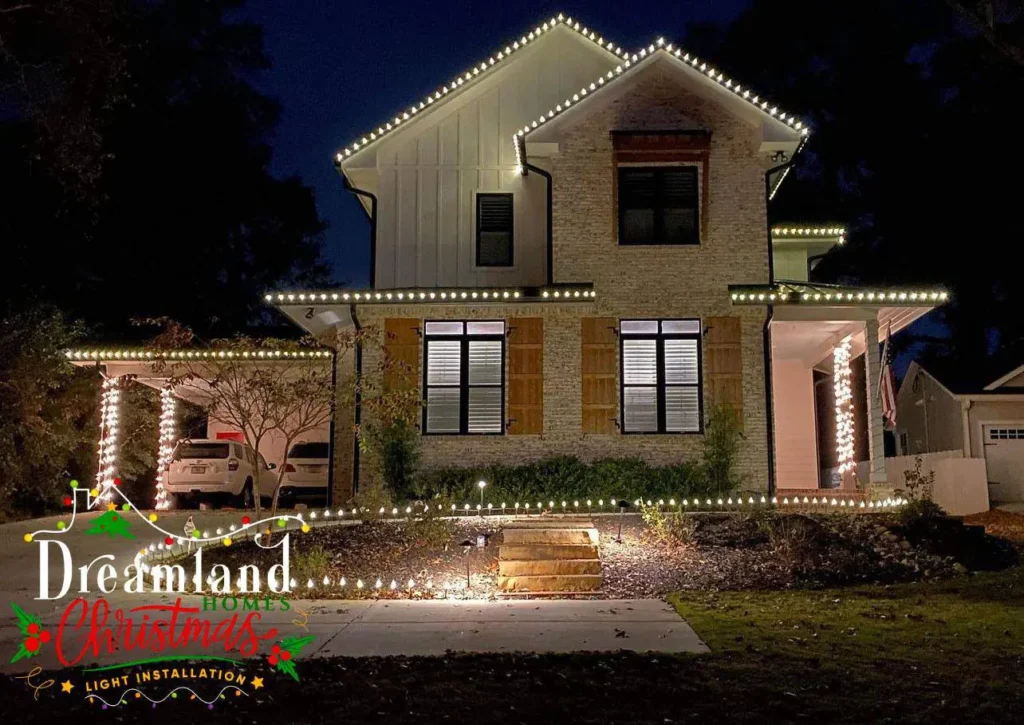 Residential home with warm white holiday lighting along rooflines and exterior architectural features.
